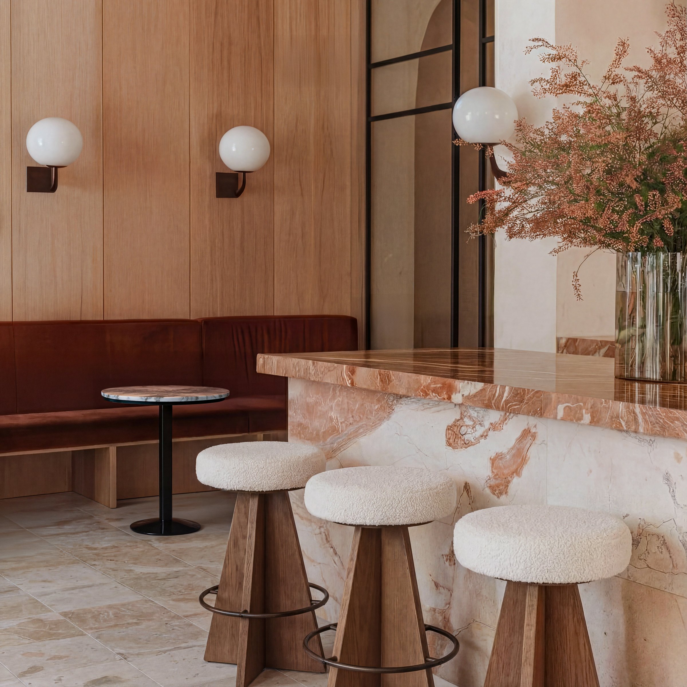 Co-living amenity space with communal seating and warm material palette — designed by Ademchic