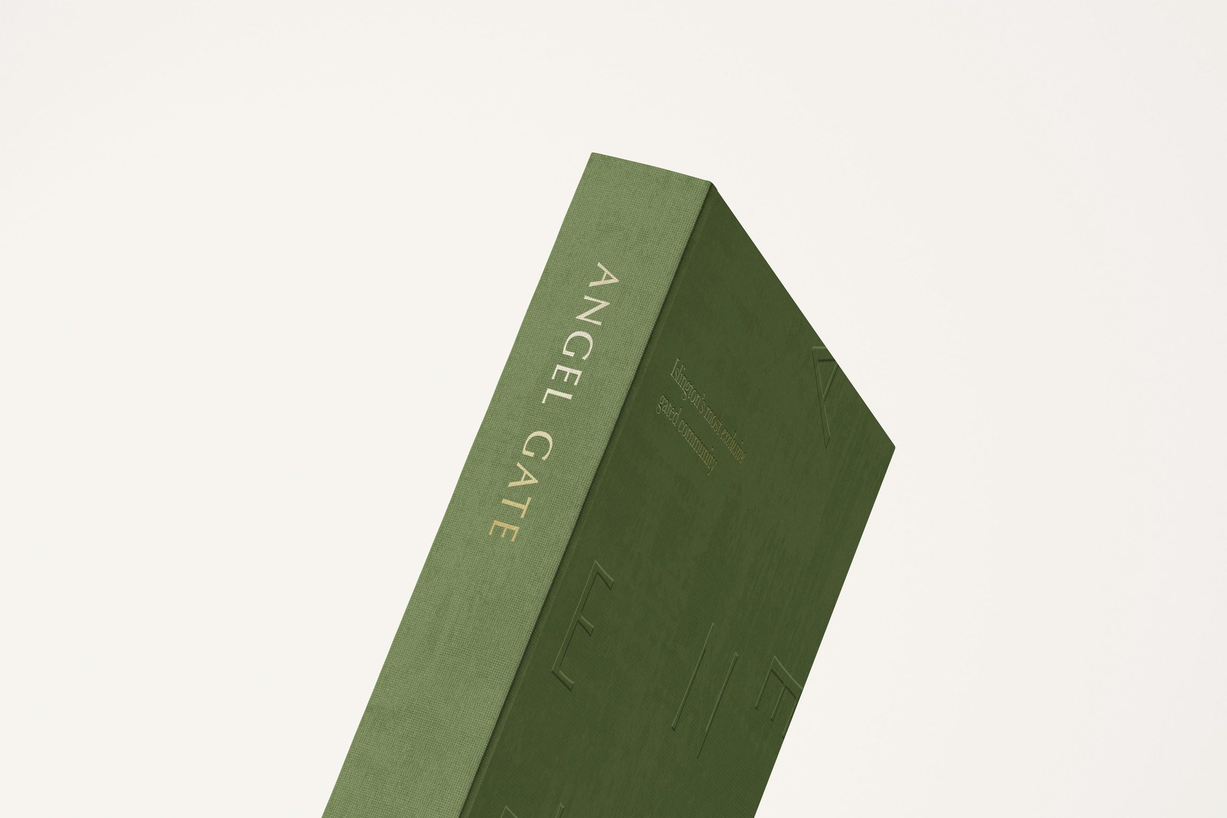 Angel Village brochure — linen-bound cover at an angle on a neutral background