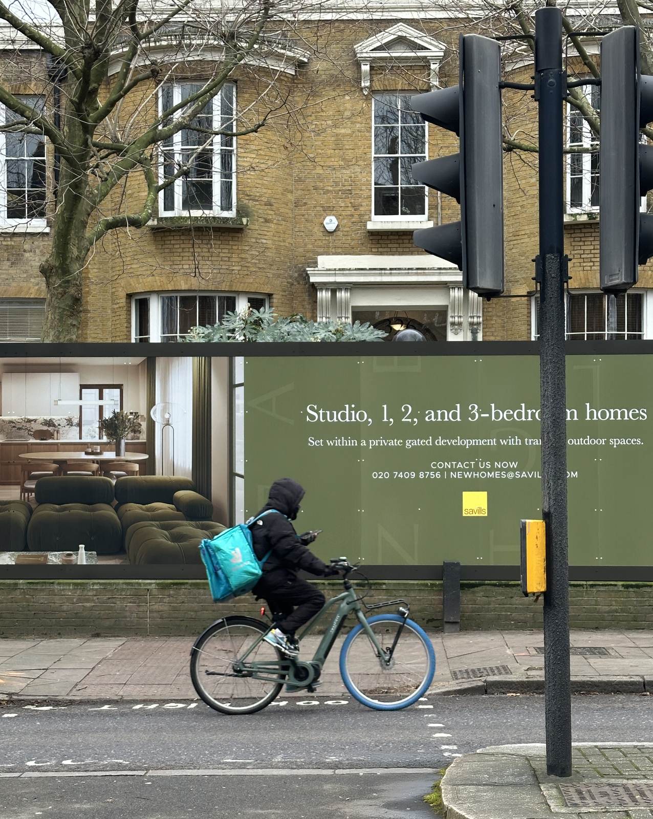 Angel Village site hoarding on street with development details and interior CGI imagery